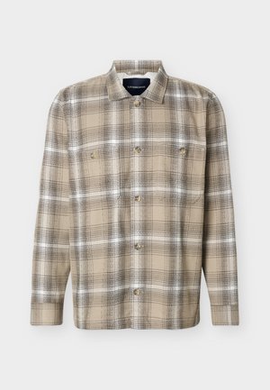 Beige og brun ternet langærmet skjorte med knapper foran og to brystlommer, vist på en hvid baggrund.