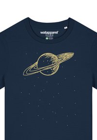 Navyblauwe katoenen T-shirt met een gouden grafiek van een planeet met ringen, omringd door kleine sterren, op een gladde stofoppervlak.