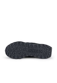 Suela de zapatilla de goma negra con un patrón de banda rugoso, que presenta el logo "MUNICH" y elementos de agarre texturizados para mejorar la tracción.