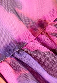 Gennemsigtigt netstof i nuancer af pink og lilla, med en bølget tekstur med plisseringer og et gradient farvemønster, der skifter fra lyst til mørkt.