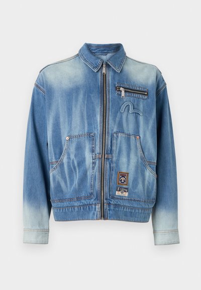 Τζάκετ από τζιν σε ξεθωριασμένο ανοιχτό μπλε χρώμα με φερμουάρ στο μπροστινό μέρος, δύο μπροστινές τσέπες, μία τσέπη στο στήθος με φερμουάρ και κεντημένο λογότυπο.
