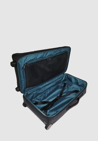 Maleta negra con ruedas, que cuenta con un interior espacioso con forro turquesa, un bolsillo de malla con cremallera y correas para asegurar el contenido.