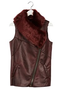 Gilet en cuir marron foncé sans manches avec col en fausse fourrure bordeaux et fermeture éclair diagonale frontale, suspendu sur un cintre blanc.