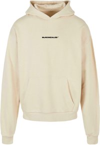 Hoodie in hellem Beige mit einer Kängurutasche. Verziert mit schwarzem Text "MJGONZALES™" auf der Brust. Weicher Stoff mit gerippten Bündchen.