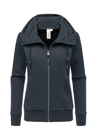 Felpa con zip di colore grigio scuro, dotata di un ampio cappuccio, coulisse regolabili, due tasche frontali e polsini e orlo a costine. Tessuto morbido al tatto.