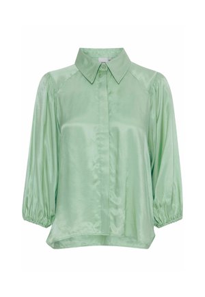Light green satin blouse with a collar, front button closure, and balloon sleeves. Smooth texture with a relaxed fit and curved hem.