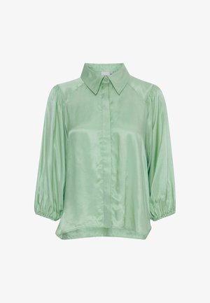 Svetlozelena satenska bluza s ovratnikom, sprednjim gumbom in balonastimi rokavi. Gladka tekstura z sproščenim krojem in ukrivljenim robom.
