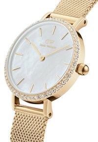 Zelta Daniel Wellington pulkstenis ar pērļu seju, kristāla rotājumiem ap malām, zeltainiem stundu rādītājiem un sietiņa siksniņu, rādītājs: 10:08.