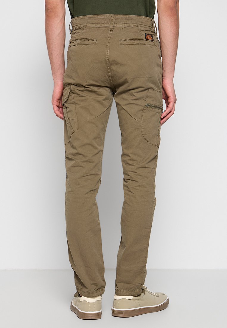 Pantalones cargo caqui con corte ajustado, que cuentan con dos bolsillos laterales tipo cargo, un bolsillo con cremallera y un parche de tela en la parte trasera.