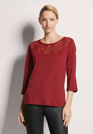 Maroon shirt with three-quarter sleeves, featuring a lace detail at the neckline. Made of soft fabric with a relaxed fit.