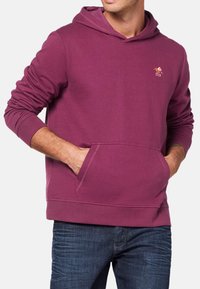 Bordowy hoodie z przednią kieszenią kangurką, ściągaczami przy mankietach oraz małym haftowanym logo na piersi. Miękka, casualowa tekstura materiału.