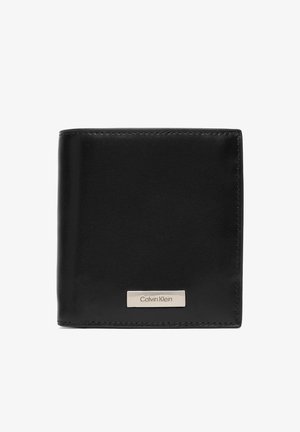 Zwarte leren bifold-portemonnee met zichtbare stiksels en een klein rechthoekig metalen Calvin Klein-logoplaatje aan de voorkant.