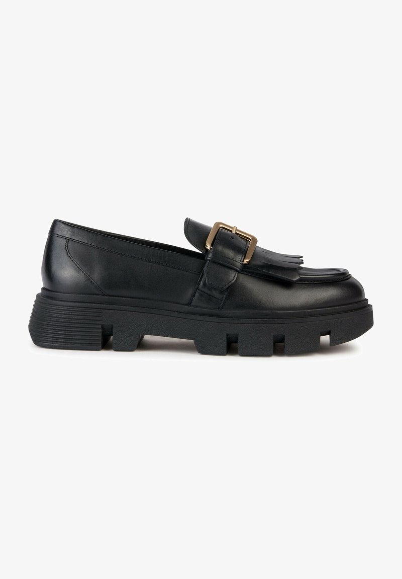 Mocassin en cuir noir avec semelle épaisse à crampons, franges décoratives et détail de boucle dorée sur le dessus.