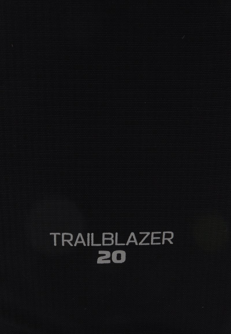 Zaino nero caratterizzato da una superficie testurizzata, etichettato "TRAILBLAZER 20" in caratteri bianchi, che enfatizza la durabilità e il design compatto.