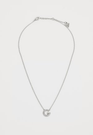 Collana d'argento con una delicata catena e un pendente circolare decorato con piccole pietre trasparenti, a forma della lettera "G."