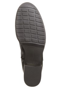 Botte en cuir noir avec une semelle en caoutchouc texturée présentant un motif en grille et un talon bas. Détail de fermeture éclair latérale pour un enfilage facile.