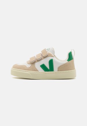 Witte en beige sneakers met groene accenten, gemaakt van leer en suede. Beschikt over twee klittenbandsluitingen en een gestructureerde rubberen zool.