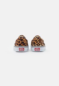 Zapatillas slip-on de lona con estampado de leopardo, suelas de goma blancas y acentos del logo de Vans en rojo. Cuentan con un cuello acolchado para mayor comodidad y flexibilidad.