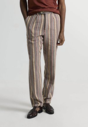 Pantalones estampados de tejido ligero, con rayas verticales en beige, amarillo y burdeos con detalles geométricos. Corte ajustado, bolsillos laterales.