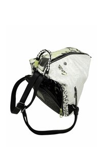 Sac à bandoulière à motifs noir et blanc avec une poignée tressée, une fermeture éclair et une sangle noire réglable. Matériaux texturés avec des accents.