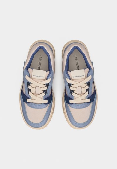 Ζευγάρι μπεζ και μπλε sneakers με κορδόνια, χοντρές σόλες και σήμανση Emporio Armani στη γλώσσα και την εσωτερική σόλα, από πάνω.