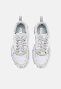 Białe sportowe sneakersy z szarymi akcentami, z siateczkowego i syntetycznego materiału, okrągłym noskiem, sznurowadłami oraz małymi, limonkowymi detalami po bokach.
