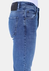 Skinnies in medium blauw denim, met een vijf-pocket ontwerp, een leren patch bij de taille en subtiele vervaging op de stof.