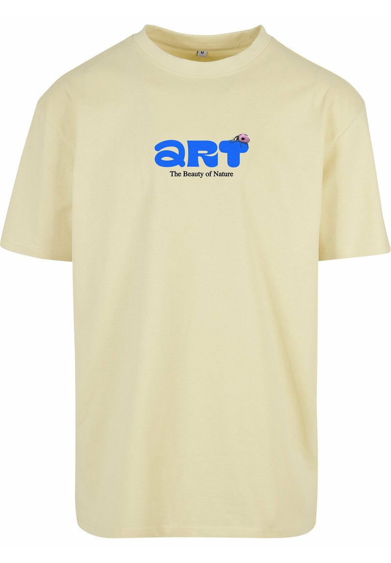 Gul bomull t-skjorte med en blå "kunst" logo og tekst som leser "Naturens skjønnhet," med en liten rosa marihøne-grafikk. Korte ermer.