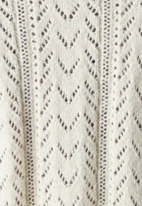 Cream-colored knit sweater featuring a chevron pattern with openwork detailing. Soft texture with a lightweight, airy appearance.
