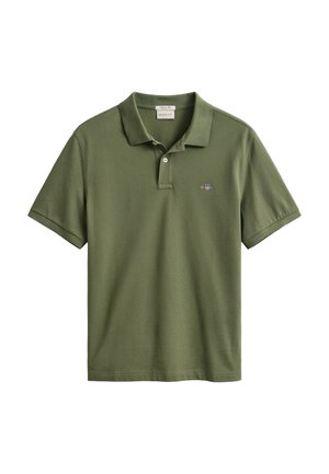 Polo manches courtes vert olive avec deux boutons et un petit logo écusson brodé sur la poitrine gauche.