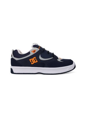 Navy blue athletic shoes with gray accents, featuring a rubber sole, lace-up design, and orange logo detail on the side.
