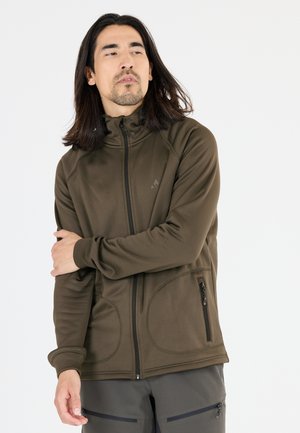 Veste zippée vert olive avec un col haut, dotée de deux poches zippées et d'un tissu lisse et extensible pour plus de confort.