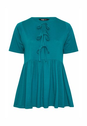 Turkoosi lyhythihainen babydoll-pusero, jossa on kolme koristetyynyä edessä ja vyötäröllä laskokset, jotka antavat väljän istuvuuden.