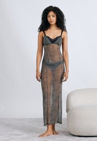 Διαφανές μακρύ φόρεμα με λεοπάρ σχέδιο σε σκούρο πράσινο και καφέ, με λεπτή δαντέλα και λεπτές τιράντες. Μαλακό, ρέον ύφασμα.