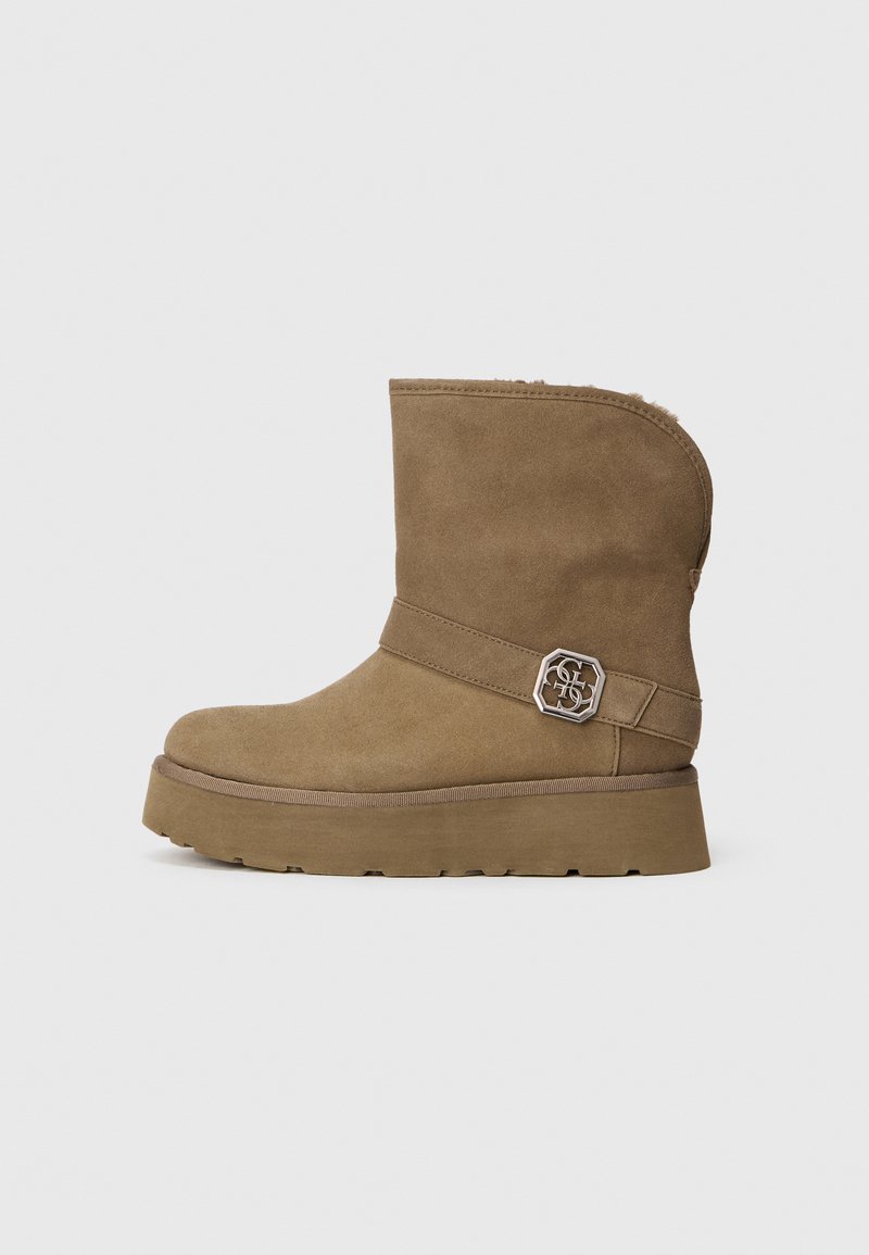 Barna velúr bokacsizma kerek orral, puha béléssel és dekoratív fém csattal a bokán. Vastag platform talppal rendelkezik.