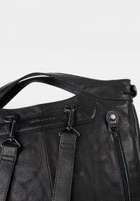 Schwarze Lederhandtasche mit glatter Textur, zwei oberen Griffen und Hardware-Akzenten, ausgestattet mit einer Reißverschluss-Tasche und gesteppten Details.