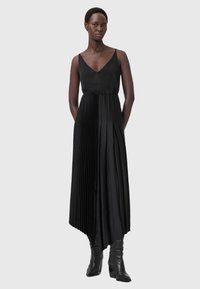 Μαύρο μακρύ φόρεμα με πτυχώσεις, V-λαιμόκοψη και λεπτές τιράντες. Κατασκευασμένο από απαλό ύφασμα, με κάθετες πτυχώσεις και εφαρμοστή μέση.