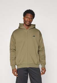 Olive green zip-up hoodie with a large hood, front pockets, and ribbed cuffs. Features a small black Adidas logo on the chest.