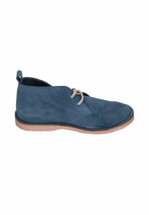 Blauer Wildleder-Knöchelstiefel mit beigen Schnürsenkeln und hellbrauner Sohle, von der Innenseite auf weißem Hintergrund gezeigt.