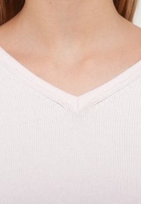 Camisola de malha cor de rosa claro com design de decote em V, textura canelada e junção sem costuras na gola. Material macio e leve.