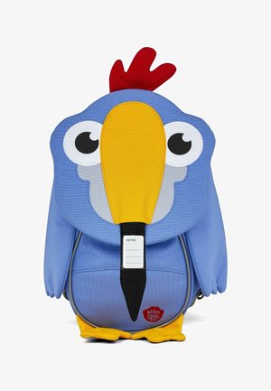 Blue backpack designed as a cartoon bird with large eyes, yellow beak, red comb, and soft fabric. Features a name tag on the front.