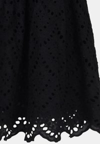 Svart spetskjol med ett blommigt hålmönster, vågformad fåll och texturerat tyg. Skuren till knälängd, vilket ger ett delikat utseende.