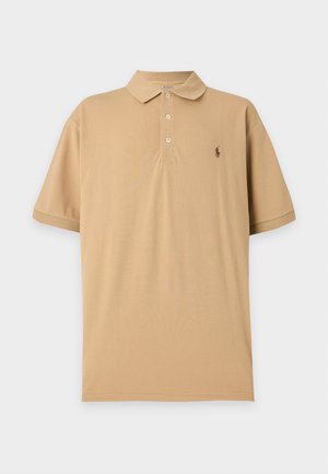 Béžové polo tričko s krátkym rukávom, tromi gombíkmi a malým vyšitým logom na ľavej strane hrudníka na jednofarebnom pozadí.