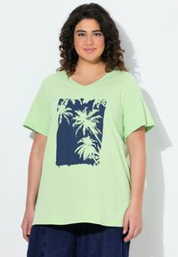 T-shirt verde chiaro con scollo a V, caratterizzato da una grafica di una palma navy all'interno di un contorno rettangolare. Maniche corte e materiale in cotone morbido.