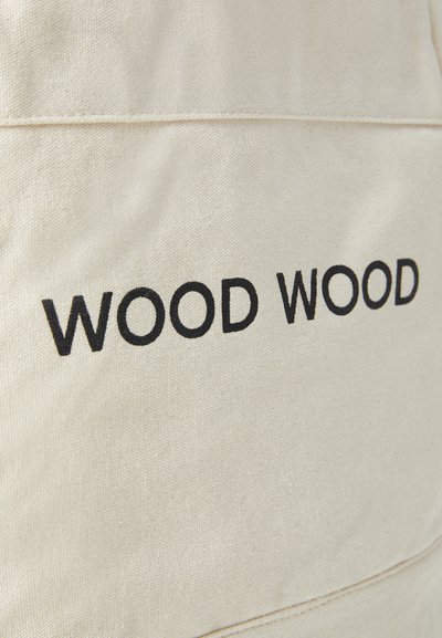 Geantă din pânză de culoare albă murdară, cu textul brodat „WOOD WOOD” în negru. Design simplu cu o suprafață texturată și detalii de cusătură vizibile.