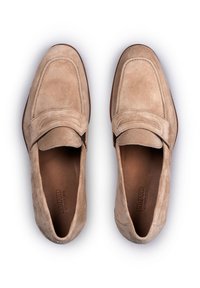 Beige suède instappers met een ronde neus, voorzien van een gestikt detail over de wreef en een gladde bruine leren voering. Platte rubberen zool.