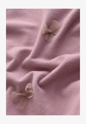 Ružičasta tkanina s mekim teksturom koja sadrži dvije male, svijetle tilaste mašne. Materijal je glatki i blago rastegnut, stvarajući nježne nabore.
