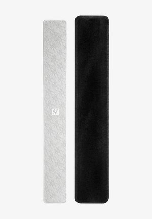 Due custodie rettangolari lunghe e strette, una bianca con motivo testurizzato e logo, l'altra nera con una superficie morbida simile al velluto.