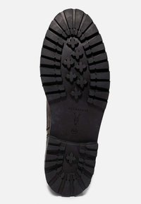 Semelle de botte en caoutchouc noir avec un motif de bande de roulement robuste, comprenant des rainures croisées et linéaires pour l'adhérence, marquée "ALLSAINTS" et taille 42.