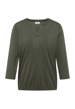 Groene blouse met lange mouwen, ronde hals, drie knopen aan de voorkant en een elastische zoom, met het label "Cecil".